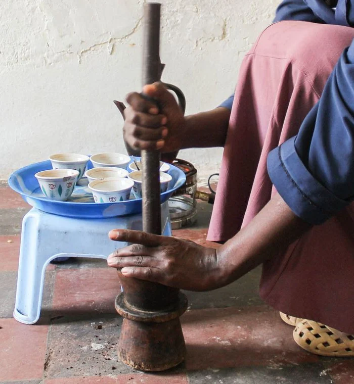 Hands grinding coffee with a mortar and pestle in Addis Ababa